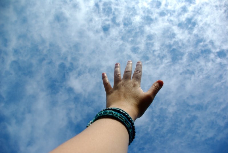 Женская рука тянется к небу