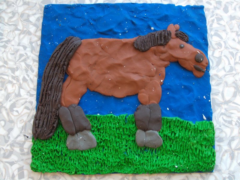 Лошадь из пластилина на картоне