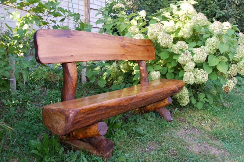Скамейки в саду из бревен