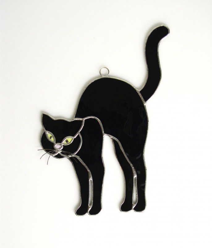 Черная кошка с выгнутой спиной